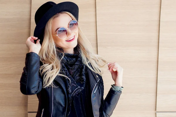 Lustige und schöne Blondine mit Sonnenbrille und Hut. trendiges Mädchenporträt im Freien. lacht und hält den Hut — Stockfoto