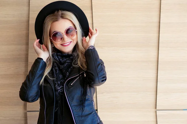 Lustige und schöne Blondine mit Sonnenbrille und Hut. trendiges Mädchenporträt im Freien. hält Hut — Stockfoto