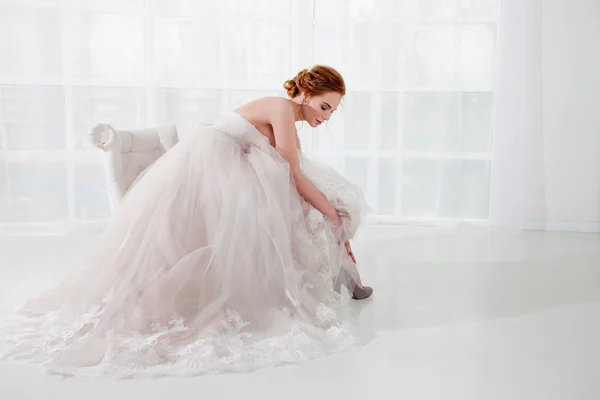 Retrato de una hermosa chica en un vestido de novia. Novia en vestido de lujo sobre un fondo blanco — Foto de Stock