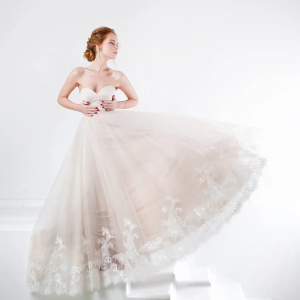 Retrato de una hermosa chica en un vestido de novia. Novia en vestido de lujo sobre un fondo blanco — Foto de Stock