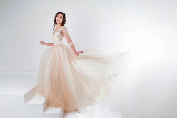 लग्नाच्या ड्रेसमध्ये एका सुंदर मुलीचे पोर्ट्रेट पायऱ्या वर उभे एक लक्झरी ड्रेस मध्ये वधू, चढणे — स्टॉक फोटो, इमेज