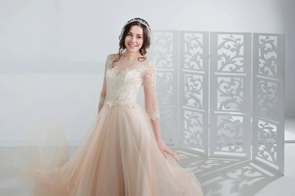 Porträt eines schönen Mädchens im Brautkleid. Braut in einem luxuriösen Kleid, in einem schönen weißen Interieur — Stockfoto