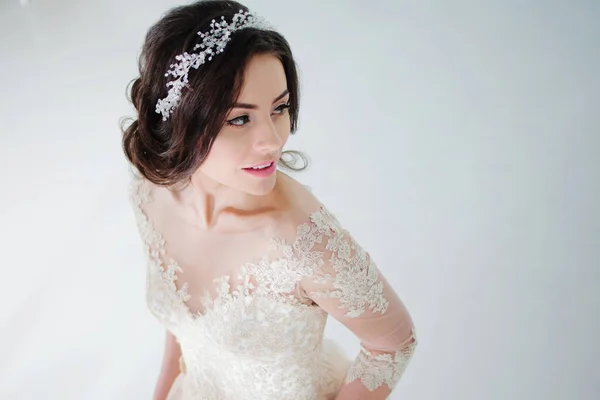 Linda noiva morena atraente em vestido de noiva com saia longa e cheia, fundo branco, lugar para texto à direita — Fotografia de Stock