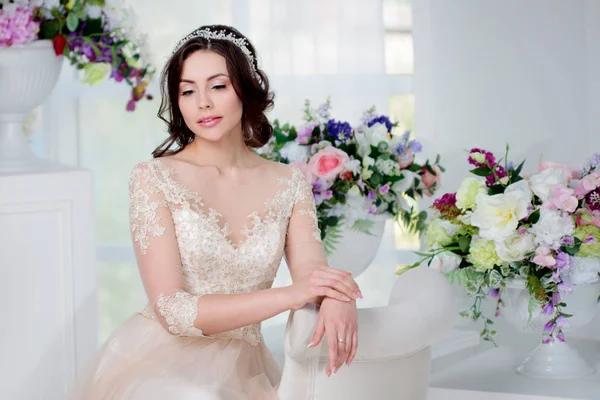 Retrato de menina bonita em um vestido de noiva de luxo. Interior decorado com flores — Fotografia de Stock