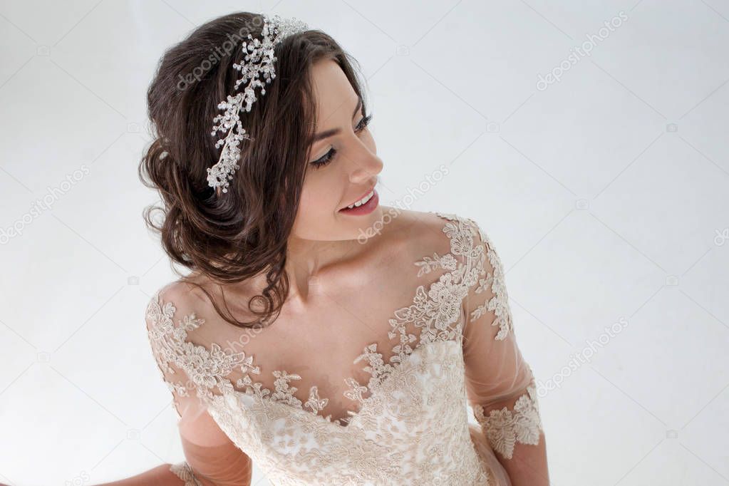 Portrait of beautiful girl in a luxurious wedding dress. Bride with beautiful decoration in her hair, smiling