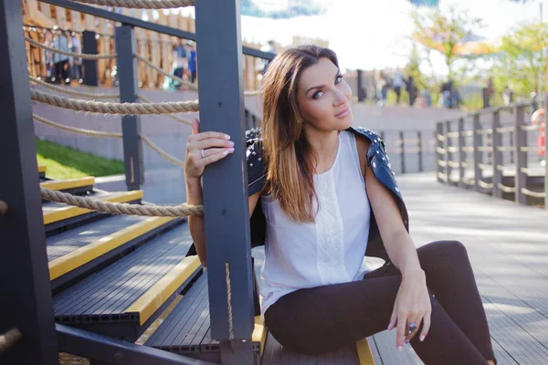 Stylish young woman on summer city walk, sitting on the stairs — Stock Photo, Image