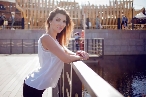 Mulher elegante em uma jaqueta de couro anda pela cidade. Olha para trás. — Fotografia de Stock