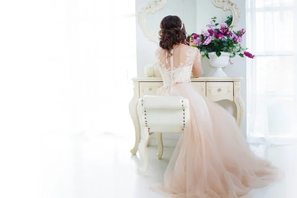 Gyönyörű lány esküvői ruha menyasszony ül fésülködő asztal. Vissza a véleményt. Szabad hely balra — Stock Fotó