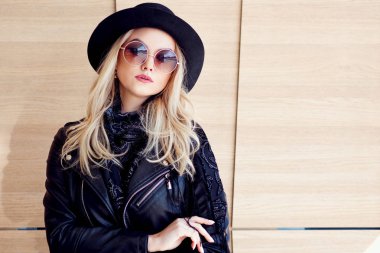 Komik ve güzel sarışın güneş gözlüğü ve şapka. Trendy kız portre açık. Şapka tutan