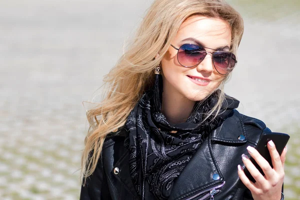 Trendiges Mädchenporträt im Freien. Ein Spaziergang durch die Stadt. junge Frau benutzt Handy — Stockfoto