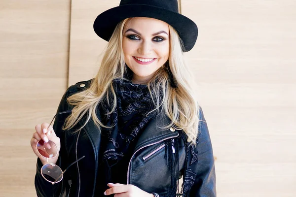 Rubia divertida y hermosa en gafas de sol y un sombrero. Chica de moda retrato al aire libre. Sostiene sombrero —  Fotos de Stock