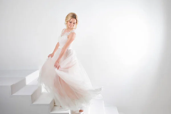 Retrato de uma menina bonita em um vestido de noiva. Noiva dançante, fundo branco . — Fotografia de Stock