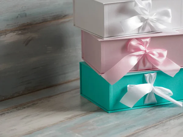 Trois coffrets cadeaux, blanc, rose et turquoise. Fond en bois . — Photo