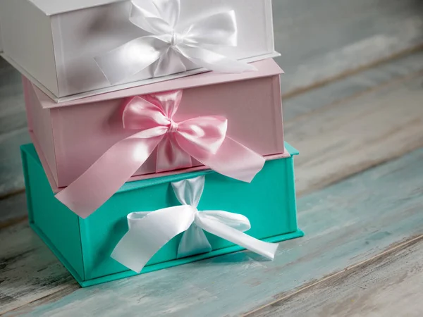 Três caixas de presente, branco, rosa e turquesa. Fundo de madeira . — Fotografia de Stock