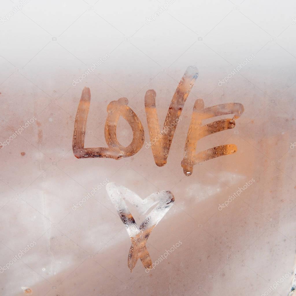 Heart painted on a misted window. Autumn rain, inscription on the sweaty glass - love and heart.