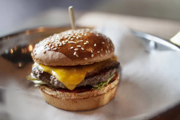 Ízletes friss házi hamburgert papírt háttér, gyorsétterem — Stock Fotó