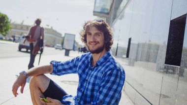 Sakallı adam müzik keyfi. Genç yakışıklı şık adam sokakta portresi.