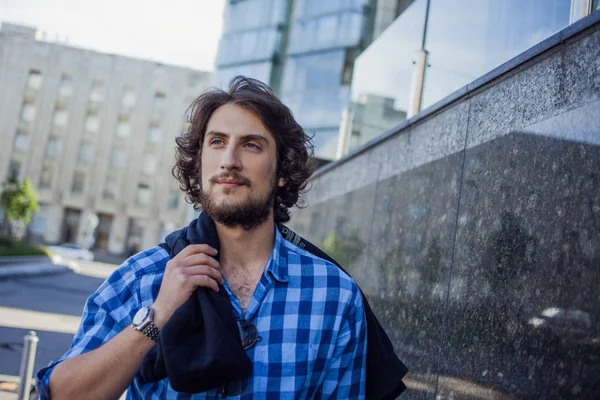 Retrato de un joven guapo y elegante en la calle. Con la sudadera al hombro — Foto de Stock