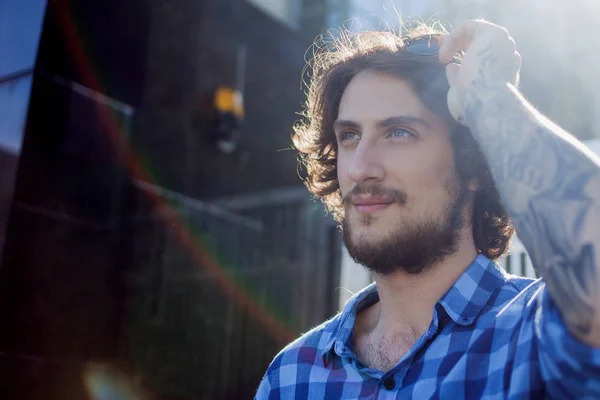 Retrato de un joven guapo y elegante en la calle. con gafas de sol — Foto de Stock