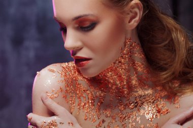 Boynundaki altın folyo ile yaratıcı görüntü güzel kızla. Mavi ve mor tonlama