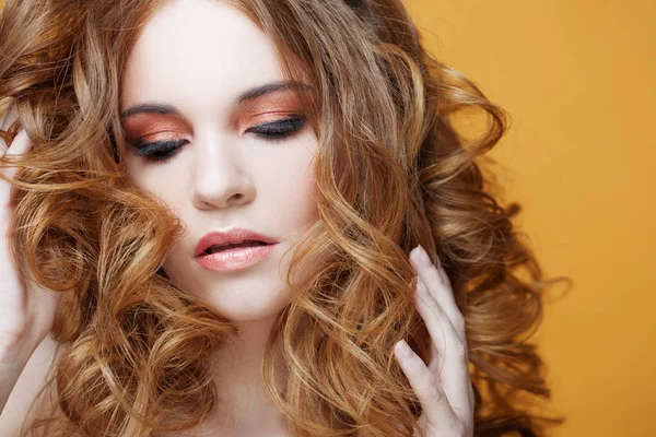 Vacker rödhårig flicka med lyxiga lockigt hår. Studio porträtt på gul bakgrund. Utmärkta hår — Stockfoto