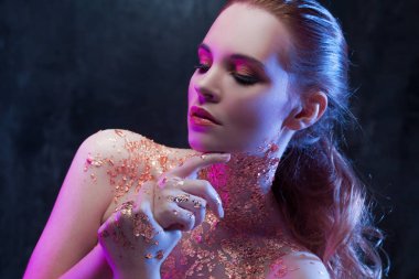 Boynundaki altın folyo ile yaratıcı görüntü güzel kızla. Mavi ve mor tonlama