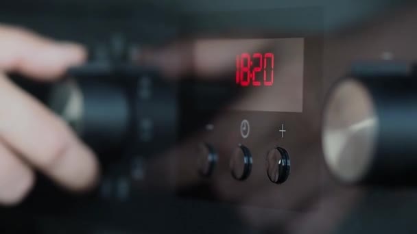 Woman engages the oven to start cooking, close-up — Stock Video