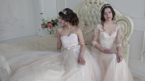 Twee mooie jonge bruid in bruiloft jurken. Huwelijk salon — Stockvideo