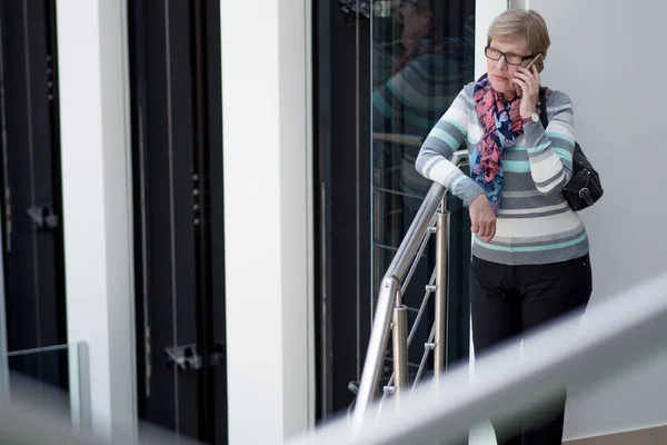 Elegant mogen kvinna använder smartphone, telefon talk, porträtt på köpcentret — Stockfoto