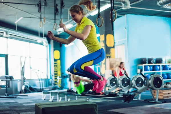 Fitness femme sautant sur la boîte d'entraînement à la salle de gym, cross fit — Photo