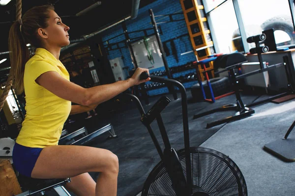 Cardio-training op een upright bike. Meisje in fitnessclub. — Stockfoto