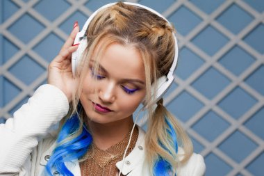 Enjoy the music. Girl with colored strands in her hair. Listening music clipart