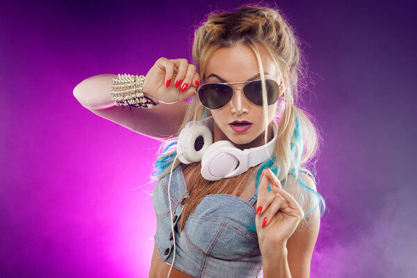 Young fashionable girl in disco style. Listening music and enjoying. Retro style
