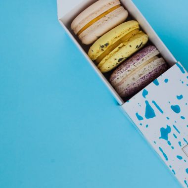 Çok güzel macarons. En baştan görüntüleyin. Mavi bir arka plan üzerinde bir kutuya