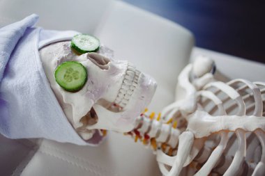 Havlu kafa ve maske yüzünde, salonuyla Spa iskeleti rahatlatır, bakım kendilerini. Saçma bir kavram, sosyal parodi. Kendine iyi bak güzelliği ve iç barış hakkında unutmak
