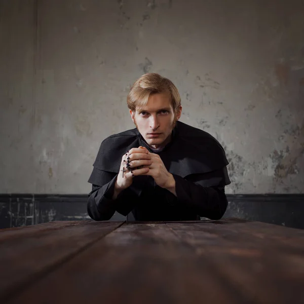 Portrait of handsome young catholic priest praying to God. Dark style, concept doubt — Stock Photo, Image