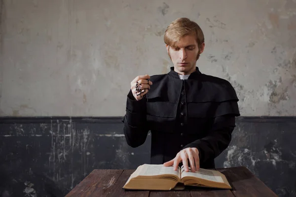 Portrait of handsome young catholic priest praying to God. — Stock Photo, Image