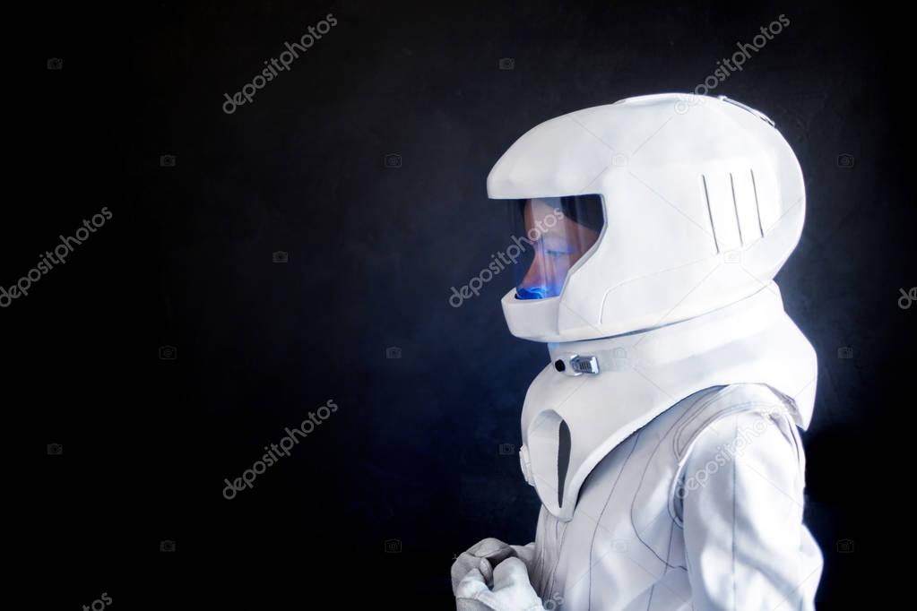 Female astronaut looking left on something. Fantastic space suit. Exploration of outer space.