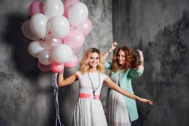 Sarışın ve Kızıl saçlı. İki genç kız partide büyüleyici. Balonlar ile mutlu ve neşeli kız.