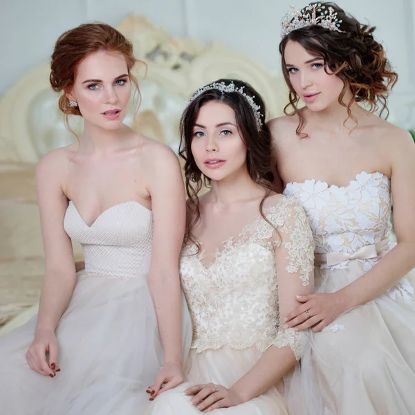 Tre ragazze in abiti da sposa. Belle ragazze delicate nel salone da sposa — Foto Stock