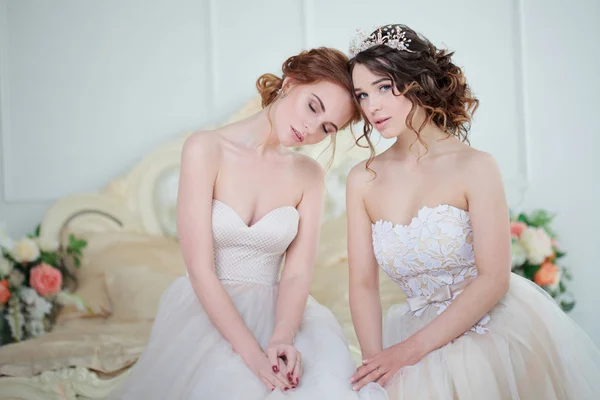 Две девушки в свадебных платьях. Красивые нежные девушки в свадебном салоне — стоковое фото