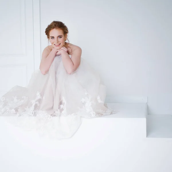 Πορτρέτο του ένα όμορφο κορίτσι σε ένα γαμήλιο φόρεμα. Νύφη στο πολυτελές φόρεμα κάθεται στο πάτωμα — Φωτογραφία Αρχείου