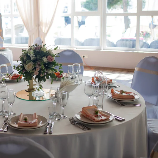 Beautiful wedding table, round table for guests, bouquet of flowers in the center