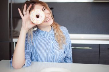Sevimli genç kadın mutfakta. Tatlı yemek istiyor çörek sırlı. Komik suratlar yapmak