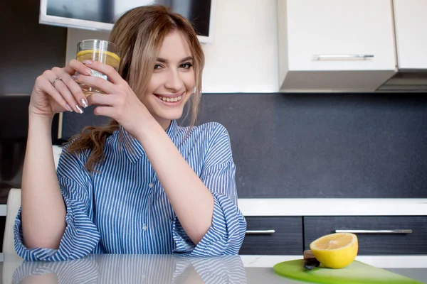 Hermosa chica comienza su mañana con un vaso de agua con limón —  Fotos de Stock