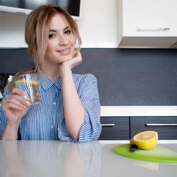 Красива дівчина починає свій ранок зі склянкою води з лимоном — стокове фото
