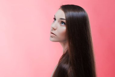 Pembe bir arka plan üzerinde mükemmel saçlı esmer Güzellik Portresi. Saç Bakımı