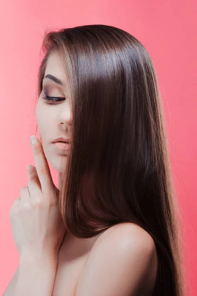 Retrato de beleza de morena com cabelo perfeito, em um fundo rosa. Cuidados com o cabelo — Fotografia de Stock