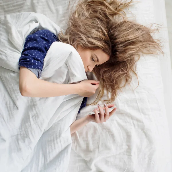 Sabah, battaniyenin altındaki kadın alarmı kapatır ya da sosyal medyayı izler.