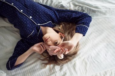 Mavi pijama ve uyku maskesi takmış, güzel bir sarışın.